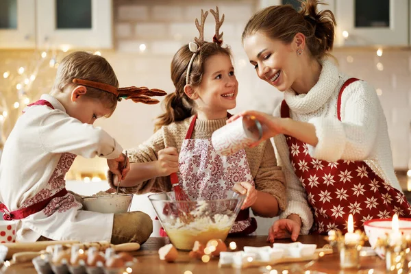 Happy family mother and two little kids making Christmas homemade cookies at home — Stock Photo, Image
