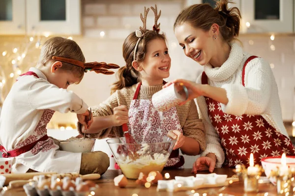 Lycklig familj mamma och två små barn att göra julen hembakade kakor hemma — Stockfoto