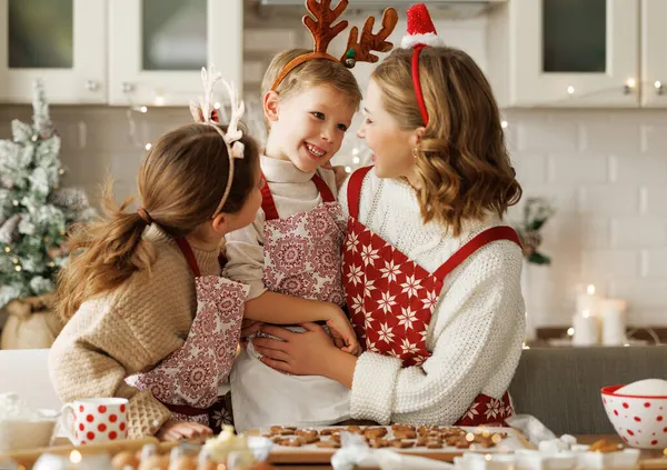 Gelukkige grappige familie moeder en kinderen genieten van kersttijd thuis, bakken van kerstkoekjes — Stockfoto