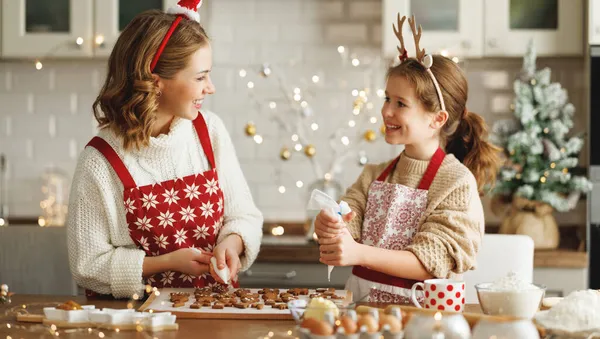 Boldog család anya és lánya díszítő karácsonyi mézeskalács sütemények sütés után — Stock Fotó