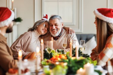 Genç aile çifti erkek ve kadın Noel 'i yaşlı aileleriyle birlikte evde kutluyor.