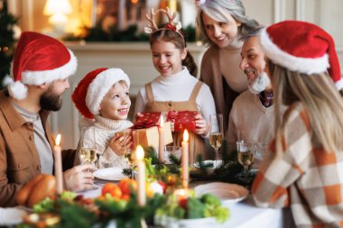 Mutlu, çocuklu bir aile Noel sabahı evde hediyelerini değiş tokuş ediyor.
