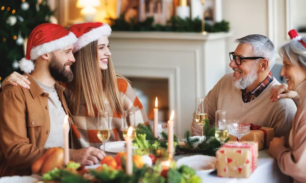 Familia joven pareja hombre y mujer celebran la Navidad con los padres mayores en casa — Foto de Stock