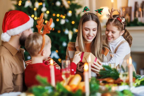Familia feliz con dos niños celebran la Navidad en casa, padres e hijos intercambian regalos de Navidad —  Fotos de Stock