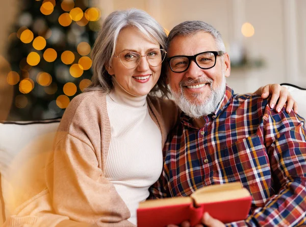 Jovem casal de família sênior feliz no amor desfrutando férias de Natal juntos em casa, livro de leitura — Fotografia de Stock