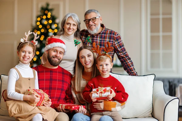 Glad flergenerationsfamilj firar nyår eller julafton tillsammans hemma nära julgranen — Stockfoto