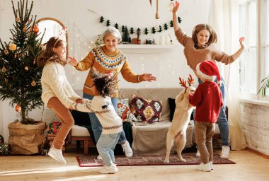 Üç çocuklu ve Golden Retriever 'lı mutlu çok ırklı aile Noel günü evde iyi eğlenceler.