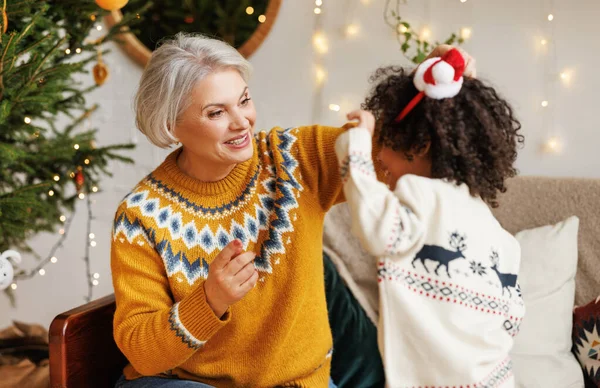 Glückliches kleines afrikanisch-amerikanisches Kind spielt am Weihnachtstag zu Hause mit der Großmutter — Stockfoto