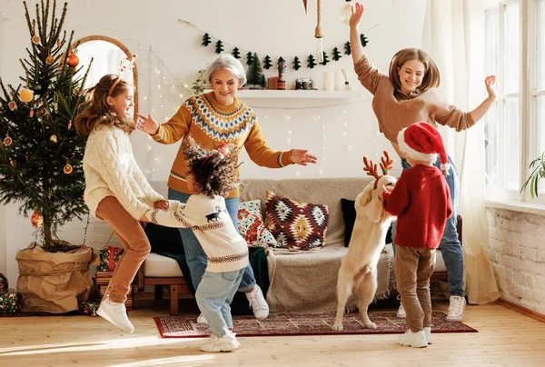 Gelukkig multiraciaal gezin met drie kinderen en golden retriever veel plezier op kerstdag thuis — Stockfoto