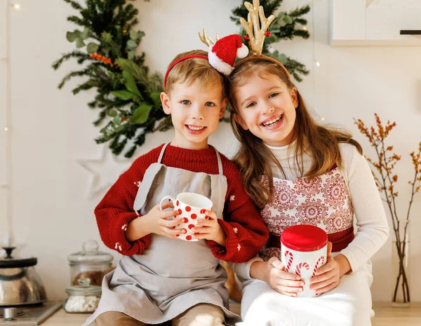 Souriant enfants heureux garçon et fille dans des tabliers cuisine le jour de Noël dans la cuisine décorée confortable — Photo