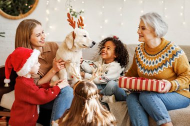Mutlu çocuklar Noel 'de köpek alıyor. Golden Retriever' lı çok ırklı aile yeni yılı kutluyor.