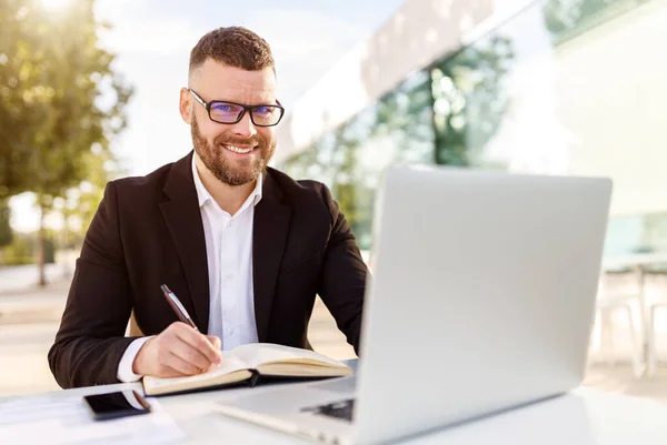 Stilig ung man entreprenör att ta en kopp kaffe medan du håller möte online utanför på café — Stockfoto