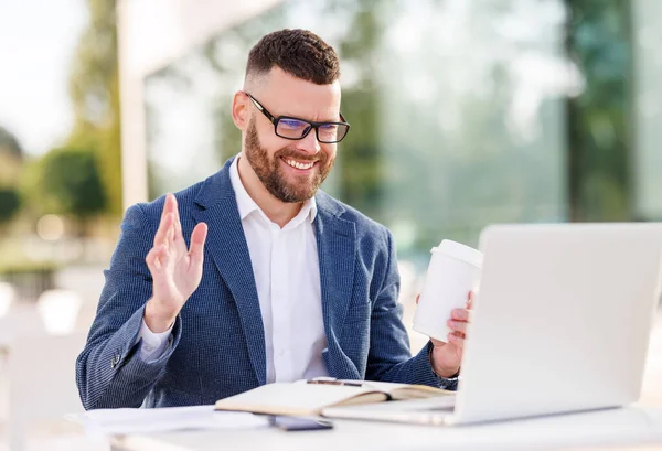 Glad ung lärare i formell outfit och glasögon ger lektion online sitter med bärbar dator utanför — Stockfoto