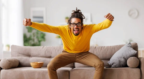 Overblij opgewonden jonge Afrikaanse Amerikaanse man viert doel tijdens het kijken naar voetbalwedstrijd op tv — Stockfoto