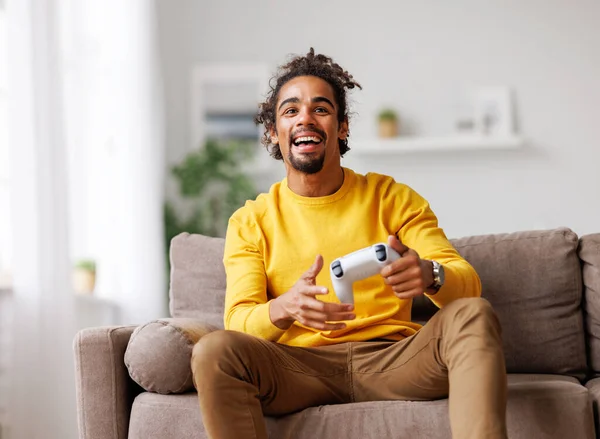 Fiatal pozitív boldog afro-amerikai srác vezeték nélküli gamepad videojáték otthon — Stock Fotó