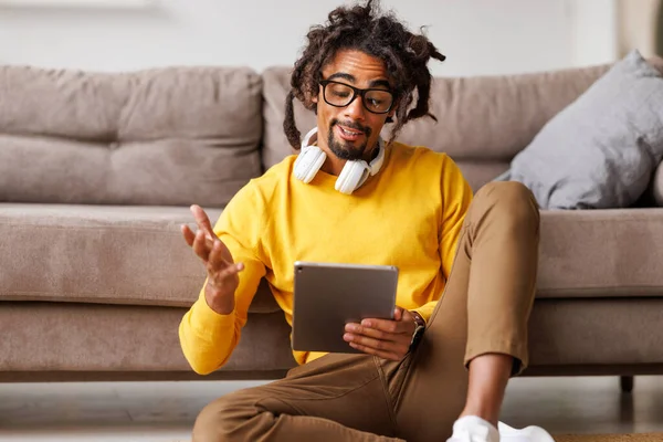 Jonge Afrikaans-Amerikaanse man met digitale tablet en praten via videogesprek tijdens zelf-isolatie — Stockfoto