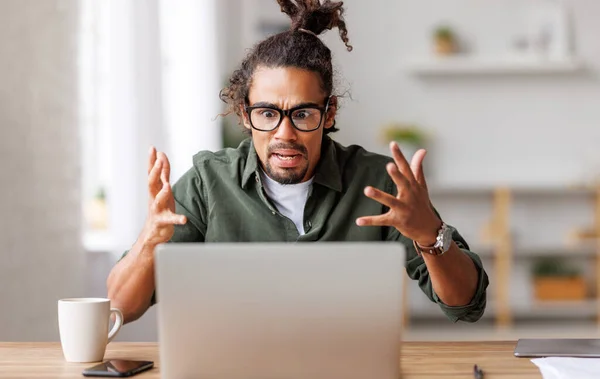 Boos jong Afrikaans Amerikaans op zoek naar laptop gevoel gestrest met trage internetverbinding — Stockfoto