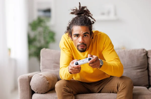 Jovem positivo feliz afro-americano cara com gamepad sem fio jogando videogame em casa — Fotografia de Stock