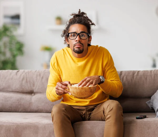 Cansado de cansaço afro-americano assistir tv com controle remoto enquanto relaxa em casa — Fotografia de Stock
