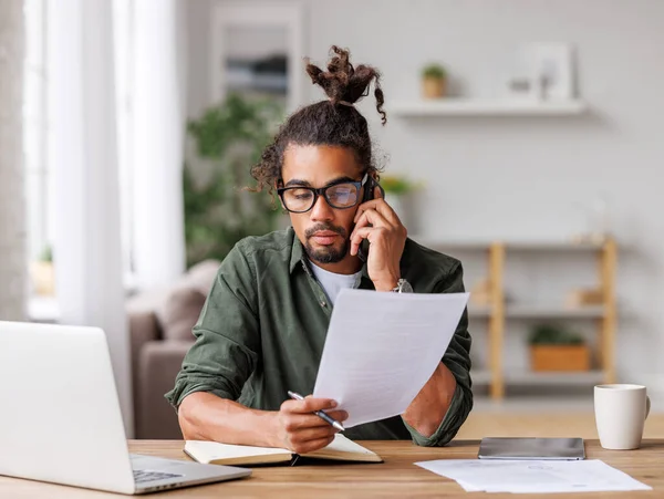 Jonge gefocuste drukke man ondernemer bellen via smartphone terwijl het werken op afstand van huis — Stockfoto