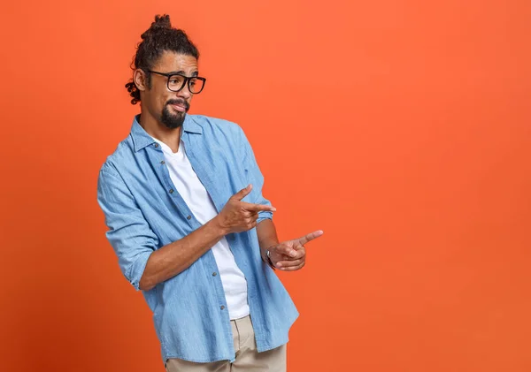 Young happy african american man in glasses pointing with forefinger at copy space — Stock Photo, Image