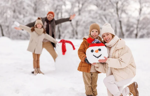 Cheerful family parents with kids in snowy winter park have fun and actively relax outdoors — Stock Photo, Image