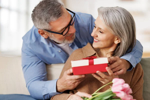 Homem sênior romântico parabenizando esposa feliz no Dia dos Namorados em casa — Fotografia de Stock