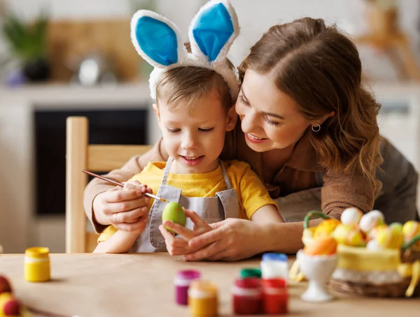 Mulher encantada e menino pintando ovos de Páscoa juntos — Fotografia de Stock