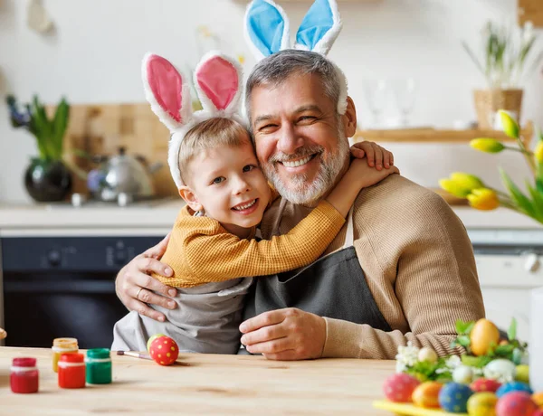 Felice famiglia amorevole nonno e carino nipotino bambino abbracciare mentre la pittura uova di Pasqua — Foto Stock