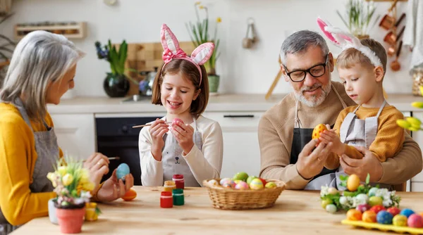 행복 한 어린이들 이사 랑많은 연로 한 조부모와 함께 부활절을 위해 아름다운 페인트칠을 한 달걀을 만드는 모습 — 스톡 사진