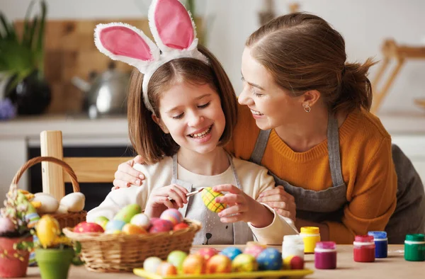 Mujer y chica encantadas pintando huevos de Pascua juntas — Foto de Stock