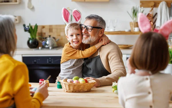 Feliz familia abuelo y pequeño nieto sosteniendo cesta de mimbre llena de huevos cocidos pintados — Foto de Stock