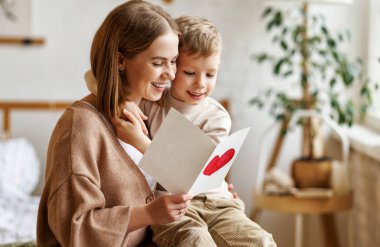 Anne ve oğul tebrik kartı okuyorlar.