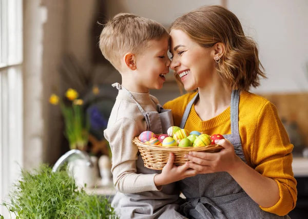 Sweet family portrait of young mother and little son with wicker basket full of painted Easter eggs Royalty Free Stock Photos
