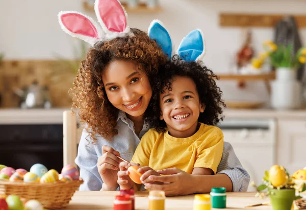快乐的非洲裔美国家庭：妈妈教快乐的小孩在厨房里装饰复活节彩蛋 — 图库照片
