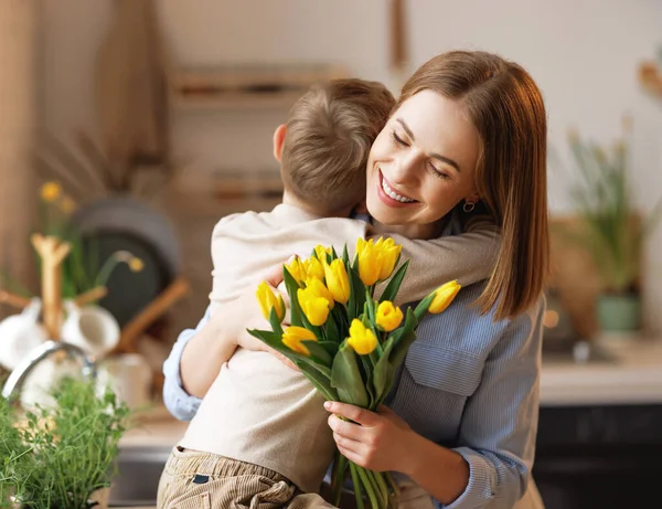 Dankbare moeder met boeket knuffelen zoon — Stockfoto