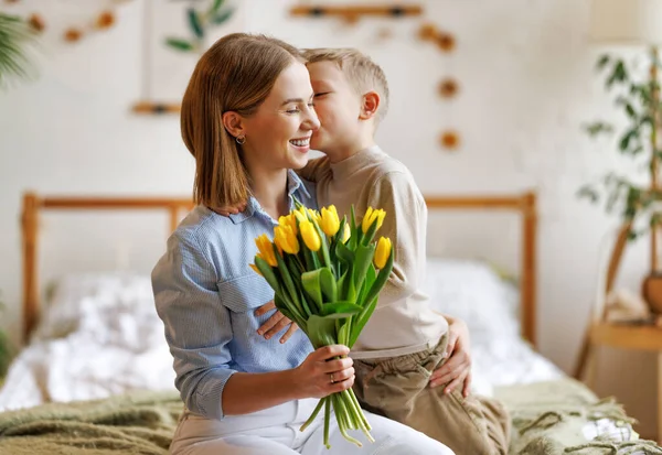 Dankbare Mutter mit Strauß umarmt Sohn — Stockfoto