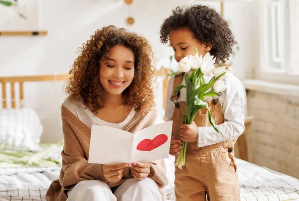 Young ethnic woman getting congratulations from son on Mothers day — Stock Photo, Image