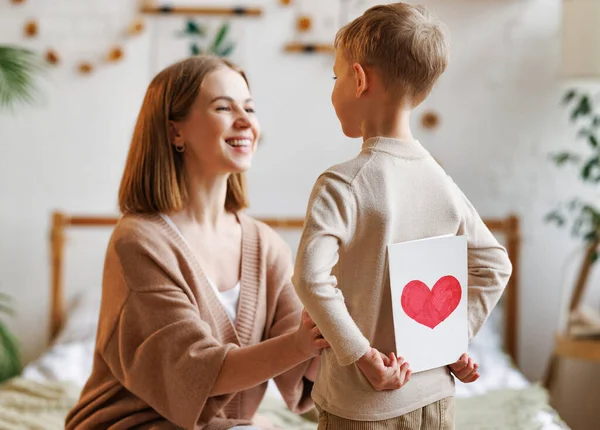 Veselá matka děkuje synovi s ručně vyrobenou pohlednicí — Stock fotografie