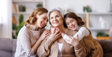 Mutlu çok nesilli aile: Kanepede kızı ve torunu olan yaşlı kadın