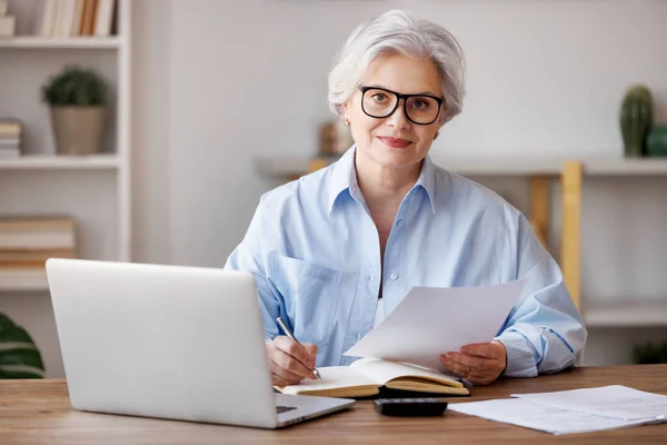 Smiling middle aged businesswoman working in home office — Stock Photo, Image