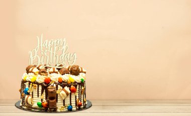 Doğum günü pastası çikolata parçalarıyla süslenmiş Tahta tahtada mutlu yıllar metni