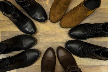 Şık deri bir çift bilek ve ahşap arka planda izole edilmiş topuklu çizmeler.