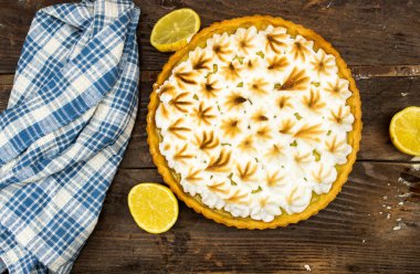 Ev yapımı limonlu pasta ve ahşap arka planda limon meyvesi.