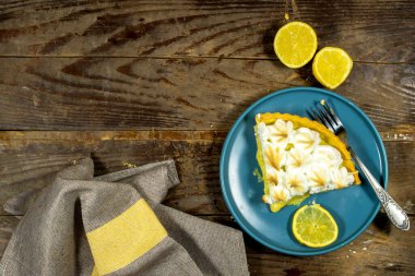 Tahta arka planda limon meyveli ev yapımı limonlu pasta.