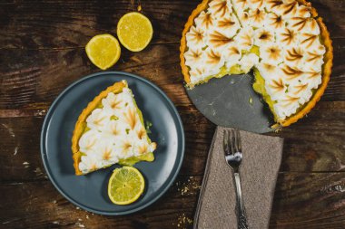 Ev yapımı limonlu pasta ve ahşap arka planda limon meyvesi.