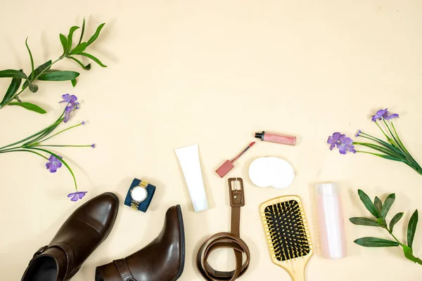 A set of fashionable clothes and accessories. tube cream face and ankle boots and hand watch, hairbrush with lipstick and belt. Makeup remove skin care