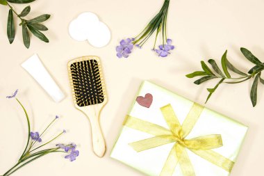 Makyaj cilt bakımını kaldırır. Plastik bir şişede yüz derisi ya da makyaj malzemesi ve pembe arka planda hediye kutusu. Hijyen malzemeleri, güzellik aletleri ve ten, çiçekler.