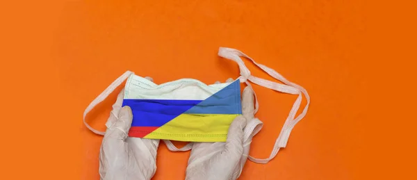 Kvinna Som Innehar Medicinsk Mask Med Flaggor Ukraina Och Ryssland — Stockfoto