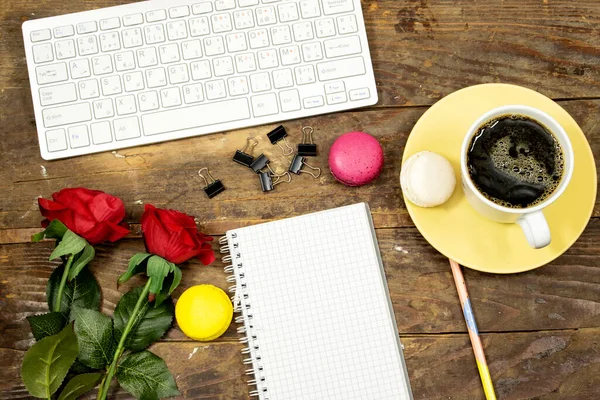 flat lay desktop, Modern computer keyboard, flower's roses and cup coffee and macarons and notebook or agenda for your text or design